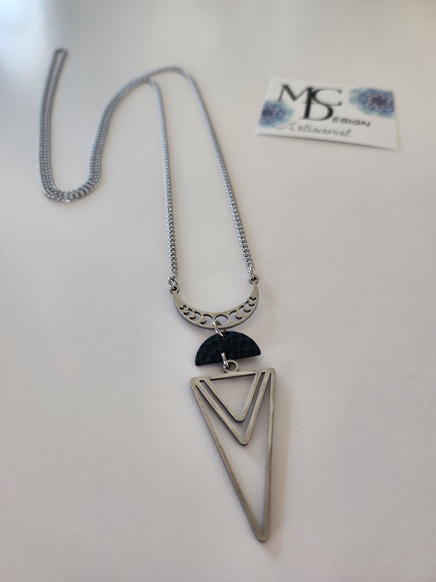 Superbe collier inox avec croissant de lune, breloque noir et pendentif triangle. 