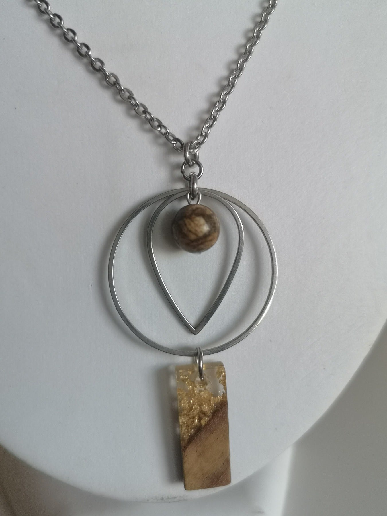 Magnifique collier long, fait avec pendentif de cercle et forme de goutte avec pierre de Jaspe Picasso er breloque carré en bois et résine. Collier très versatile et se porte avec beaucoup de style.